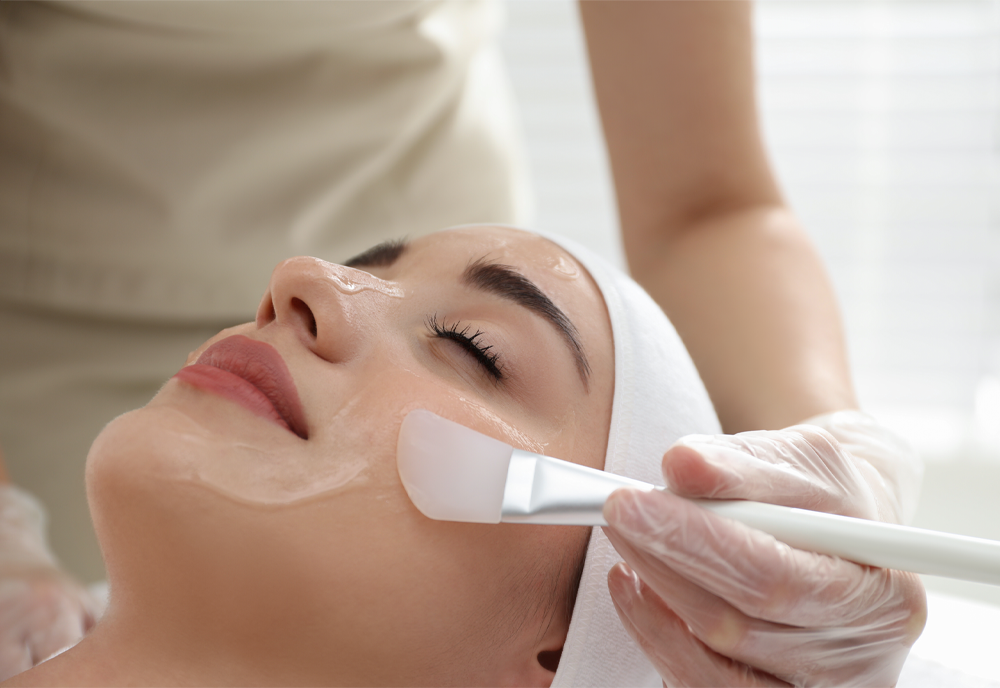 Young woman during chemical peeling procedure in salon